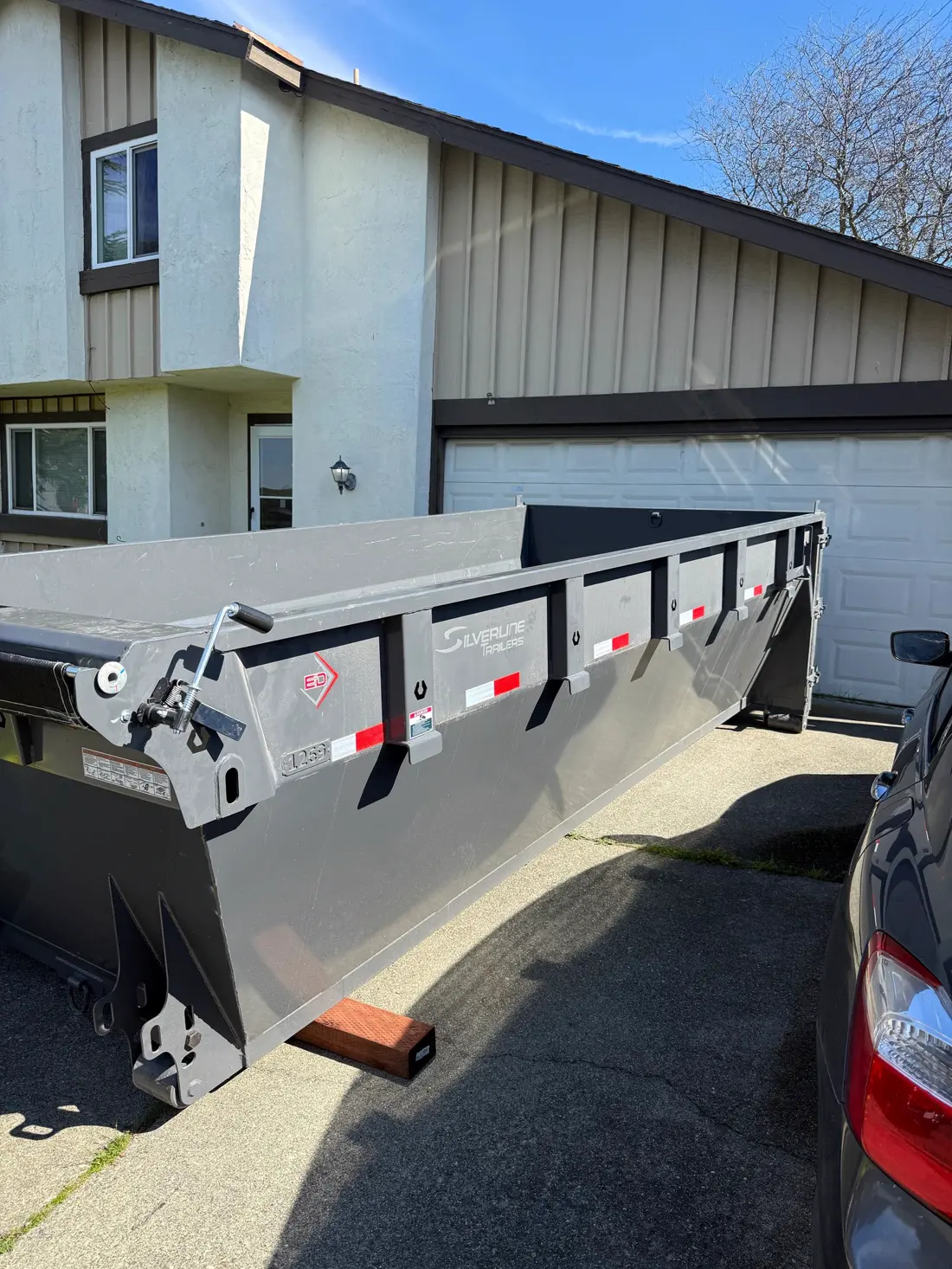 Roll-off dumpster placed carefully on a residential driveway
