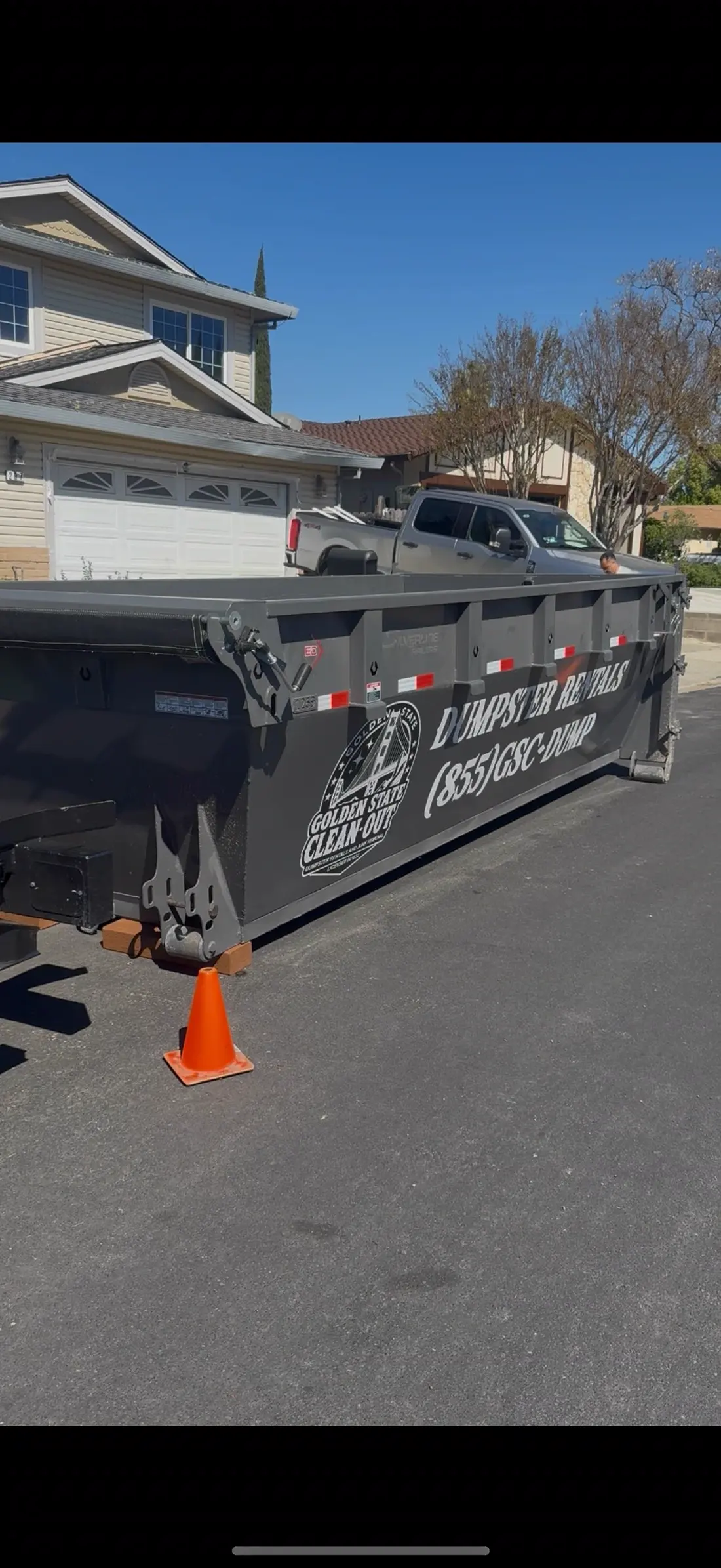 Branded Golden State Cleanout dumpster placed at the curb of a home
